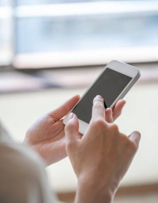 Hands of a woman who operates a smartphone